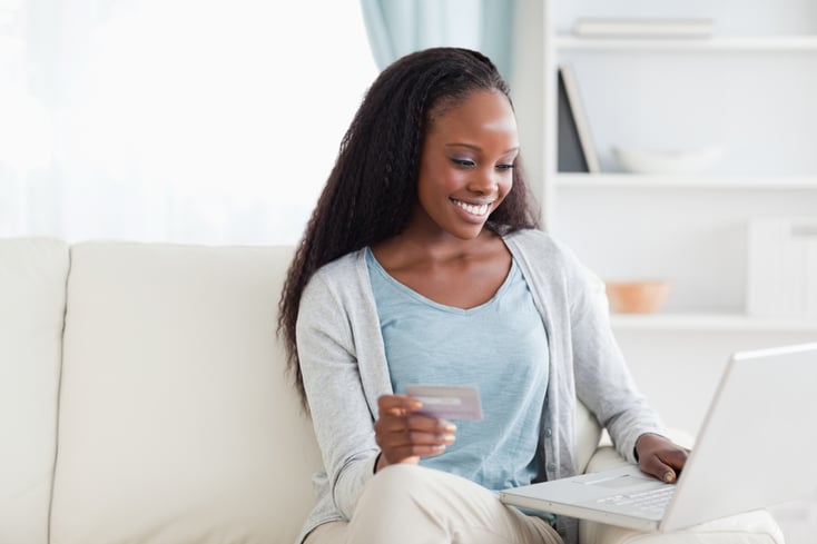 Smiling woman in living room shopping online